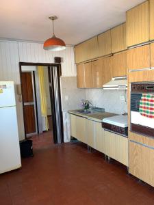 cocina con armarios de madera y nevera blanca en Amplio departamento en Godoy cruz en Godoy Cruz