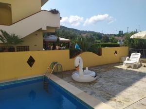 a swimming pool with a swan toy next to a house at La Playa Del Sol Tropea in Santa Domenica