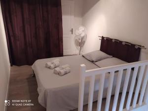 a bedroom with a white bed with two pillows on it at Duplex avec jardin, proche village in Calenzana