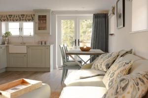 ein Wohnzimmer mit einem Sofa und einem Tisch in der Unterkunft Finwood Green Farm Holiday Cottages-The Calf Shed and The Milk Parlour in Henley in Arden