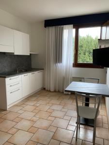 a kitchen with white cabinets and a table and a window at Hotel Lory Ficarolo in Ficarolo