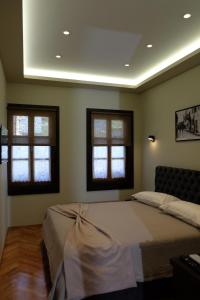 um quarto com uma cama grande e 2 janelas em Tebeu coffe and bar em Vlorë