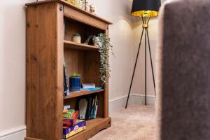 a book shelf with books in it next to a lamp at The Cosy Norse Retreat in York +29 photos