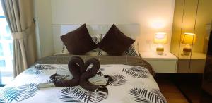Un dormitorio con una cama con zapatillas. en Eshue Designer Suites @ Simfoni Towers en Cheras