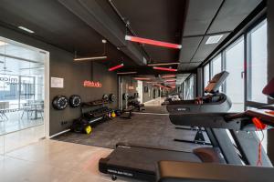 a gym with treadmills and ellipticals in a room at Micampus Alicante in San Vicente del Raspeig