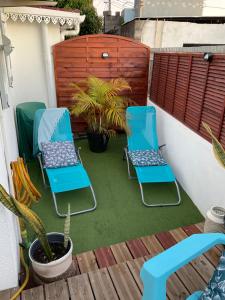 dwa niebieskie krzesła na patio z rośliną w obiekcie La Kaz Hibiscus, jacuzzi privé w mieście Le Tampon