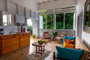 a living room with a couch and some windows at Castara Cottage by Hello Mello in Castara