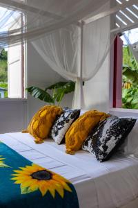 a bed with four pillows on top of it at Castara Cottage by Hello Mello in Castara