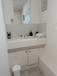 Baño blanco con lavabo y aseo en 2 Bed Functional House Close to Manor Park Train Station en Londres