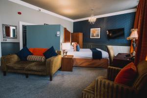 um quarto de hotel com uma cama e duas cadeiras em The Sun Hotel & Bar em Lancaster