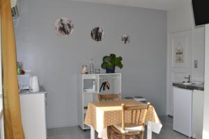 a kitchen with a table and a table and chairs at Studio + petite terrasse avec vue in Sorbier