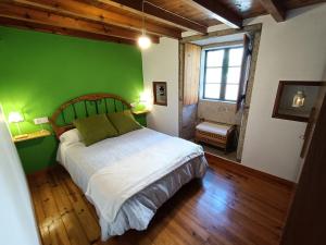 um quarto com uma parede verde e uma cama em Casa do Cucharro en Playa de Soesto, Laxe em Laxe