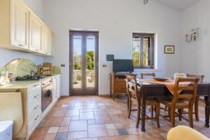 cocina y comedor con mesa y sillas en Casa Ulmi con piscina, en Uggiano la Chiesa