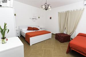 ein Schlafzimmer mit einem Bett mit orangefarbener Bettwäsche und einem Stuhl in der Unterkunft Dolce Salento in Villaggio Resta