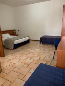 a room with two beds and a tiled floor at Hotel Lory Ficarolo in Ficarolo