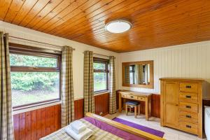 a bedroom with a bed and a wooden ceiling at Bluebell Lodge 2 with Hot Tub in Newton Stewart