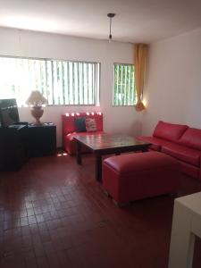 sala de estar con sofá rojo y mesa en Amplio departamento en Godoy cruz en Godoy Cruz