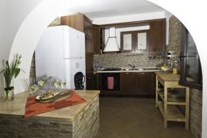 a kitchen with a white refrigerator and a table at Dolce Salento in Villaggio Resta