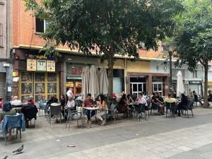 un grupo de personas sentadas en las mesas fuera de un restaurante en Precioso apartamento a estrenar en Bilbao., en Bilbao