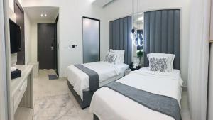 a hotel room with two beds and a bathroom at ناصرية العليا in Al Khobar