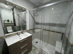 uma casa de banho com uma cabina de duche em vidro e um lavatório. em Precioso apartamento a estrenar en Bilbao. em Bilbao