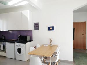 eine Küche mit einem Holztisch und weißen Geräten in der Unterkunft KYMA Apartments - Athens Acropolis 5 in Athen