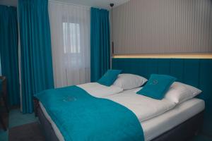 ein großes Bett in einem Zimmer mit blauen Vorhängen in der Unterkunft Friends Hotel Kerpen in Kerpen