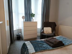 1 dormitorio con 1 cama, vestidor y silla en Talton House, en Liverpool