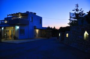 a blue house at night with the lights on at Lagos Studios & Apartments in Palekastron