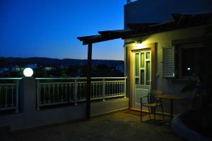 a balcony with a table and a window at night at Lagos Studios & Apartments in Palekastron
