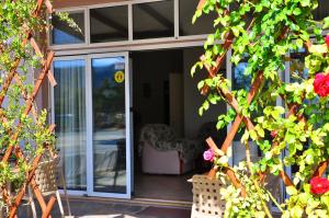 an open sliding glass door of a house at Lagos Studios & Apartments in Palekastron