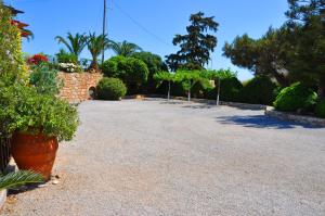 a large gravel driveway with plants and trees at Lagos Studios & Apartments in Palekastron