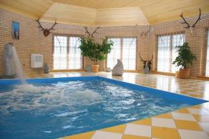 a large swimming pool in a room with a water fountain at Šeduvos malūnas in Šiauliai