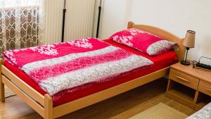 a bed with a red and white blanket on it at apartment HOME in Bihać