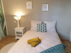 sypialnia z łóżkiem z żółtym ręcznikiem w obiekcie Cosy Opal 2CH - Terrasse & Stationnement gratuit w mieście Pau