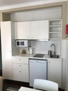 a white kitchen with white cabinets and a sink at NEW Cosy & Charming Apartment in Campolide - 3A in Lisbon