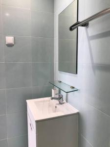 Baño blanco con lavabo y espejo en NEW Cosy & Charming Apartment in Campolide - 3A, en Lisboa