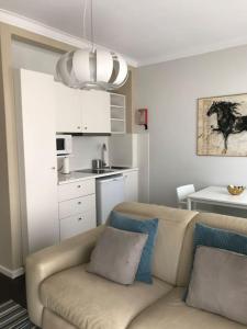 a living room with a couch and a kitchen at NEW Cosy & Charming Apartment in Campolide - 3A in Lisbon