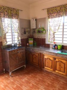 a kitchen with wooden cabinets and a stove and windows at HILAL in Sidi Bouzid