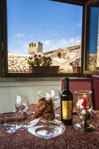 a table with a bottle of wine and glasses at Hotel Elimo in Erice