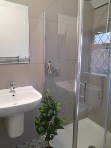 y baño blanco con lavabo y ducha. en Orchard Lane Great Glen Unique 2 bed cosy home en Great Glen