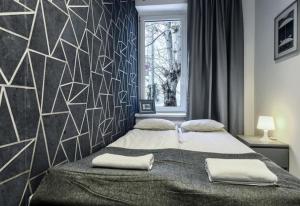 een slaapkamer met een bed met twee handdoeken erop bij MonteFerber Modern Stylish Apartment in Center of Sopot in Sopot