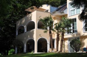 a large white house with palm trees in front of it at Park-Villen in Kressbronn am Bodensee