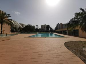una piscina en un patio con palmeras en South Beach en Portimão