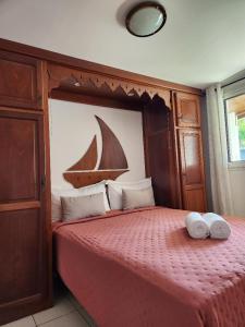 1 dormitorio con 1 cama con 2 toallas en Le Manacoël en Saint-Joseph