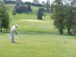 a man is playing golf on a golf course at Les Belleme Golf - Self-catering Apartments in Bellême