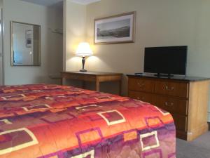 a hotel room with a bed and a flat screen tv at Apalachicola Bay Inn in Apalachicola