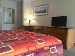 una camera con letto e TV a schermo piatto di Apalachicola Bay Inn ad Apalachicola