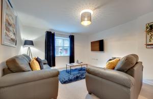 a living room with two chairs and a table at Charltons Bonds Apartments 18 by Week2Week in Newcastle upon Tyne