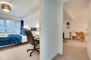 a bedroom with a bed and a desk and a chair at Charltons Bonds Apartments 18 by Week2Week in Newcastle upon Tyne